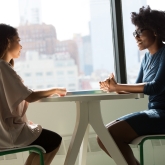 two women talking at a table