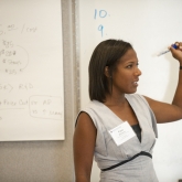 Woman presenting at a whiteboard in one of our programs