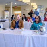 Women leaders speaking with each other during professional development event on-campus.