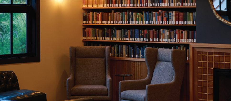 Cozy room with books, soft chairs and fireplace