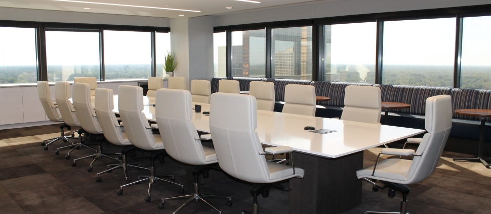 Boardroom with windows overlooking a city and no people.