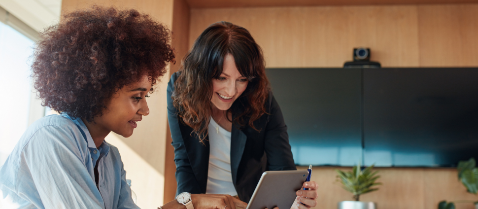 Two professional women collaborating on a financial data project.