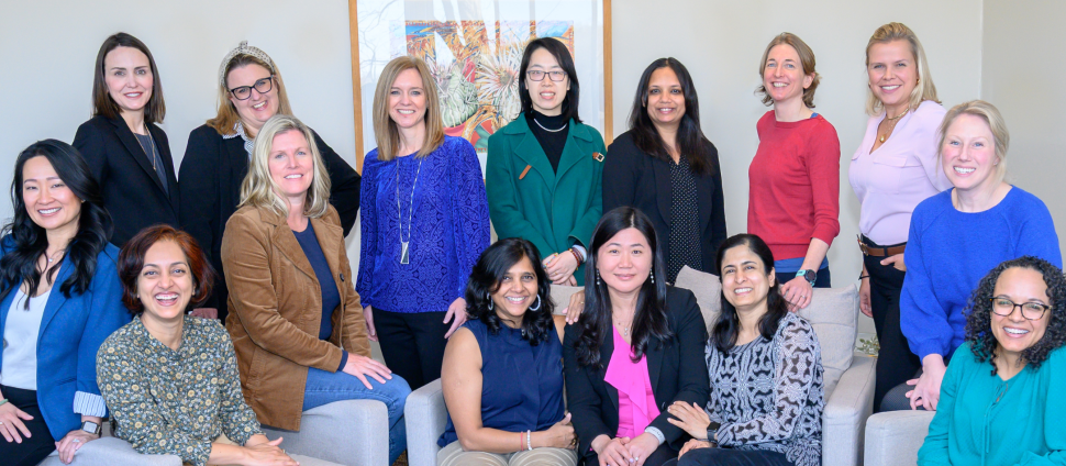 Group of diverse professionals standing together at a Smith College Exec Ed program smiling.