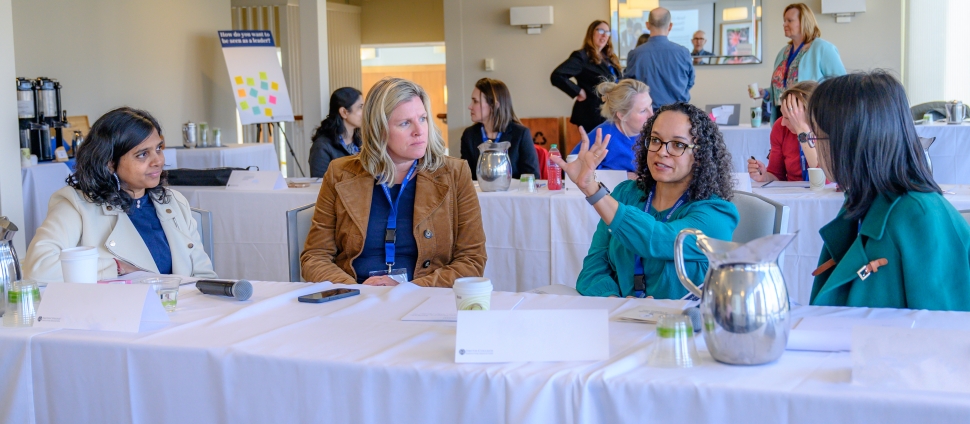 Women leaders speaking with each other during professional development event on-campus.