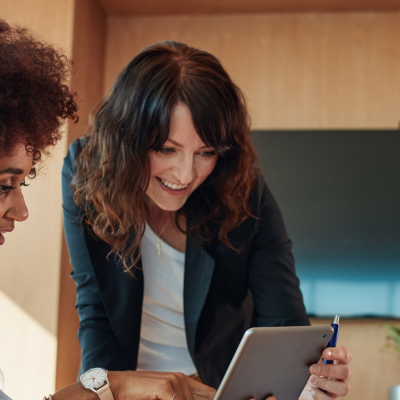 Two professional women collaborating on a financial data project.