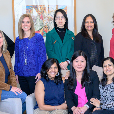 Group of diverse professionals standing together at a Smith College Exec Ed program smiling.