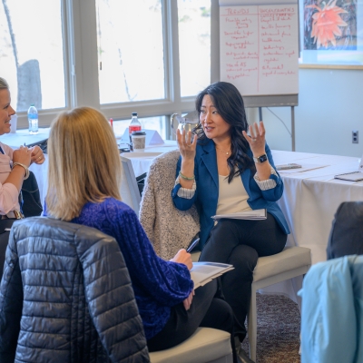 Women leaders speaking with each other during professional development event on-campus.