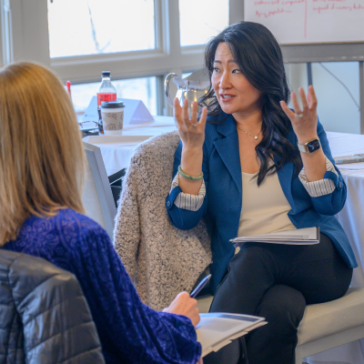 Women leaders speaking with each other during professional development event on-campus.