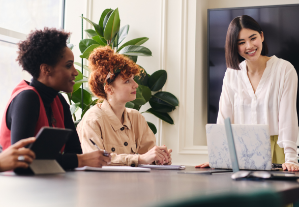 A woman wearing glasses and smiling in an office environment