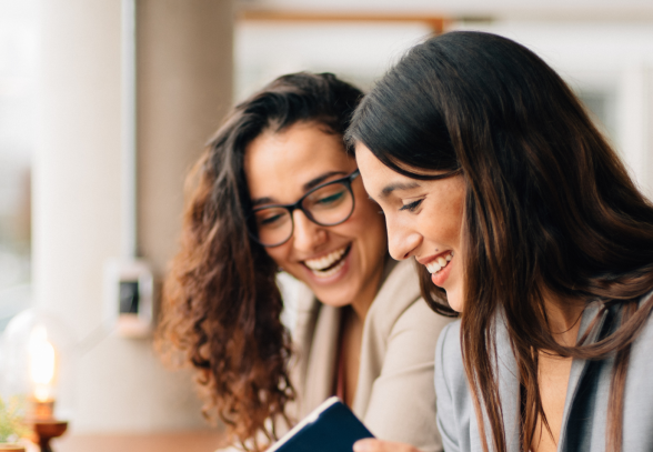 Two women talking together in a professional work setting.